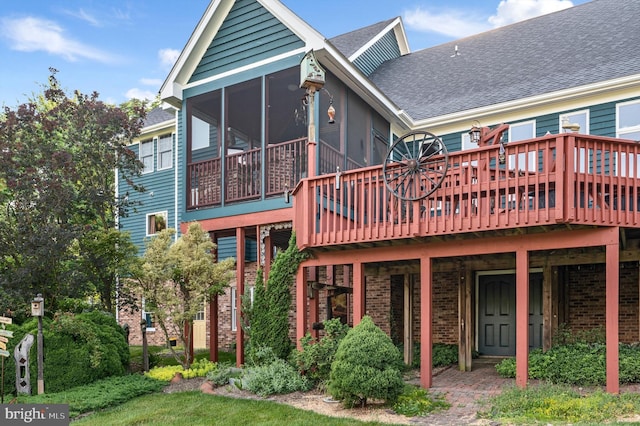 back of property with a deck and a sunroom