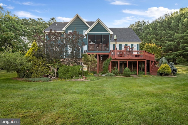 back of property with a wooden deck, a sunroom, and a lawn