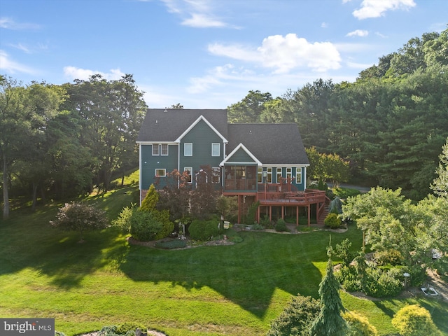 rear view of house featuring a lawn and a deck