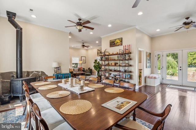 dining room with crown molding, recessed lighting, wood-type flooring, a wood stove, and ceiling fan