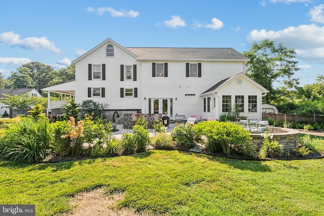 rear view of house with french doors, a yard, and a patio area