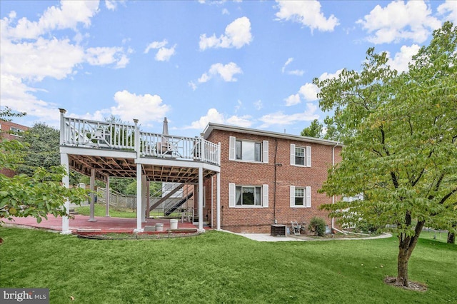 rear view of house with a wooden deck, a yard, and a patio