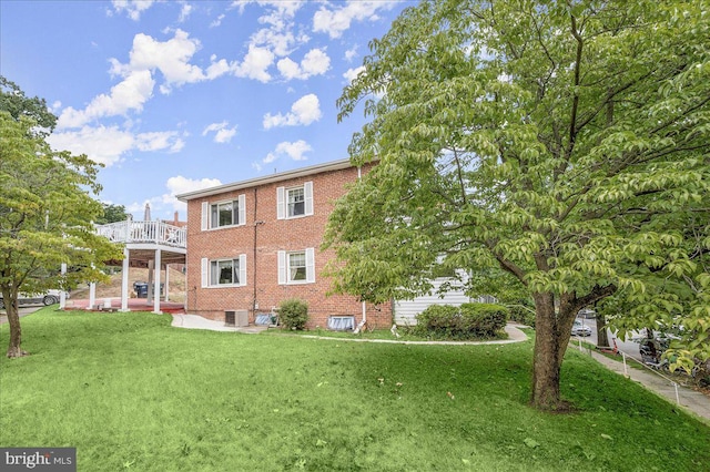 rear view of house featuring a lawn, central air condition unit, and a balcony