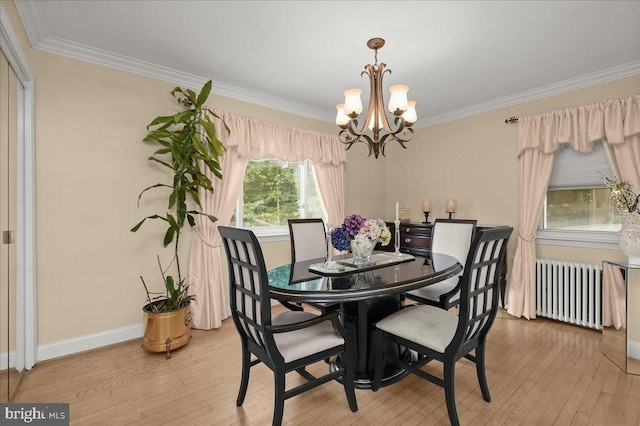 dining space with light wood-type flooring, radiator heating unit, ornamental molding, and an inviting chandelier