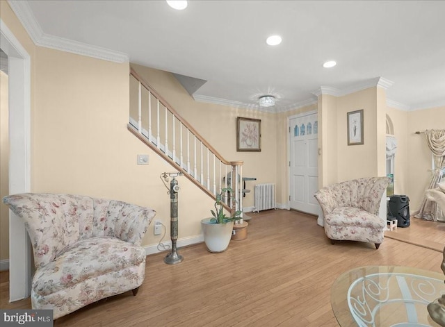 entrance foyer featuring crown molding, radiator heating unit, and hardwood / wood-style floors