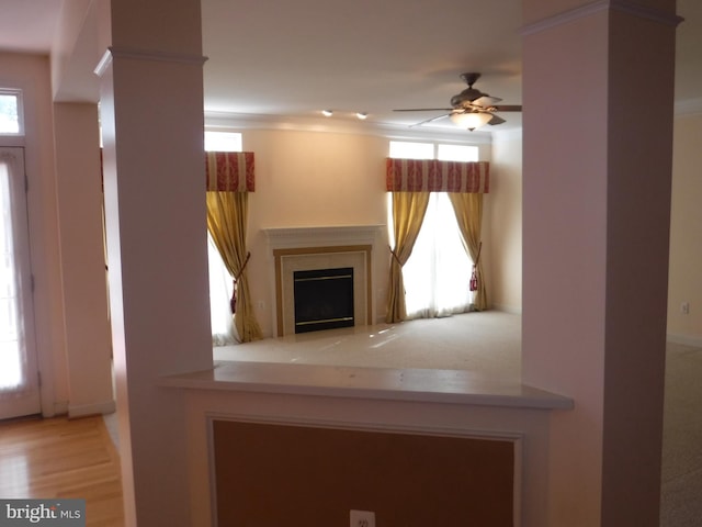 unfurnished living room featuring a high end fireplace, light wood-type flooring, and ceiling fan