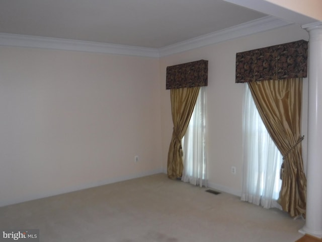 spare room featuring ornamental molding, light carpet, and decorative columns