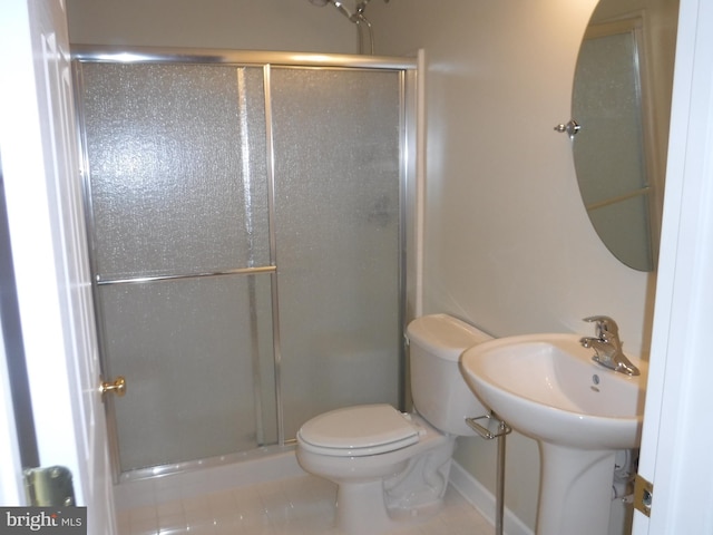 bathroom featuring tile patterned floors, toilet, and walk in shower