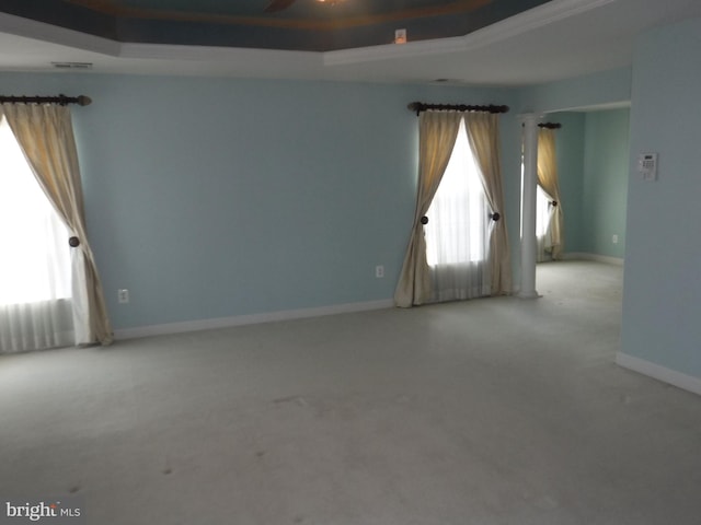 carpeted spare room with a raised ceiling and ceiling fan