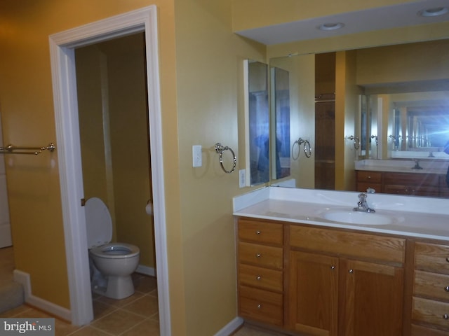 bathroom with tile patterned flooring, vanity, and toilet