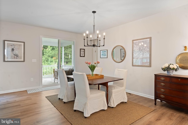 dining area featuring a notable chandelier and light wood-type flooring