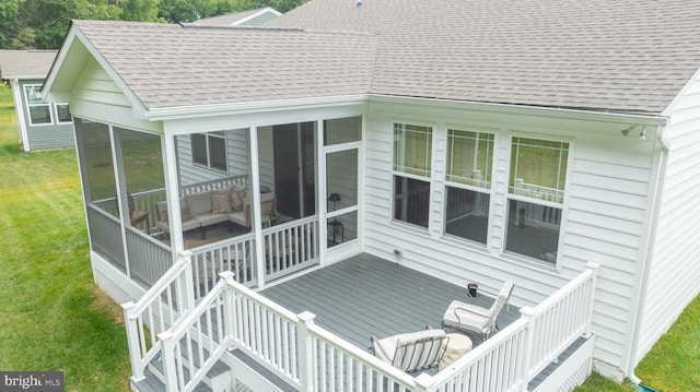 rear view of house with a sunroom and a wooden deck