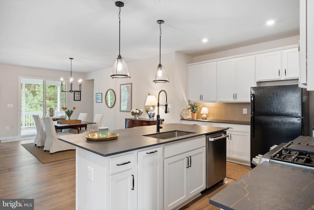 kitchen with wood-type flooring, decorative backsplash, dishwasher, and an island with sink