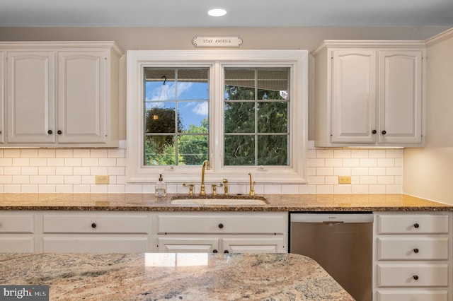 kitchen featuring white cabinetry, tasteful backsplash, dishwasher, light stone counters, and sink