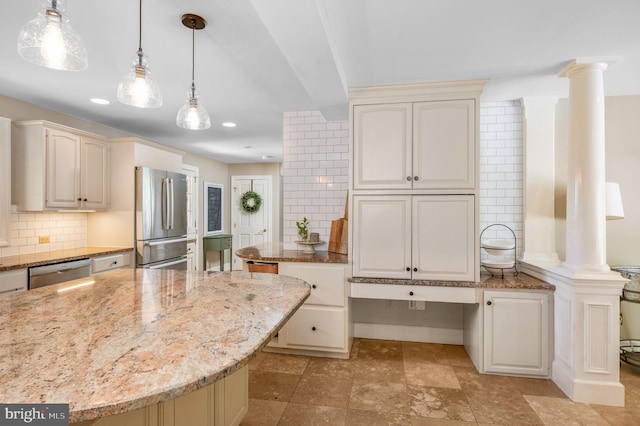 kitchen with appliances with stainless steel finishes, light stone counters, ornate columns, and a center island