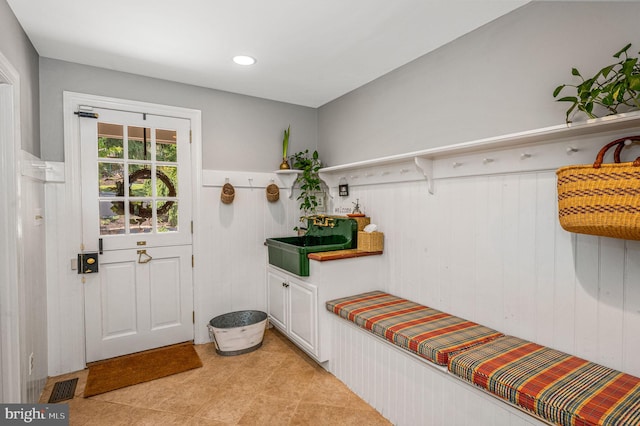 mudroom featuring sink and wood walls