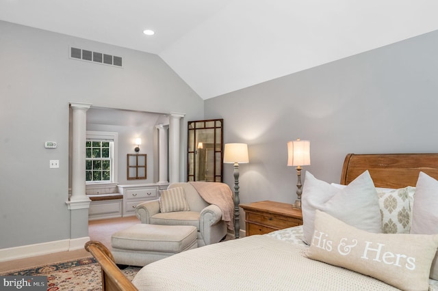 bedroom with lofted ceiling and decorative columns