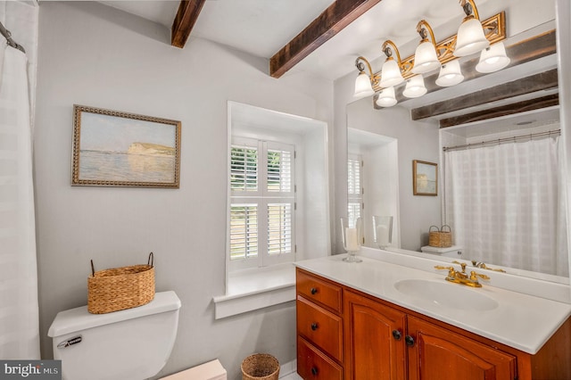 bathroom with toilet, vanity, beamed ceiling, and walk in shower