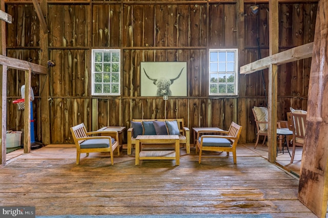 sitting room with a healthy amount of sunlight, hardwood / wood-style floors, and wooden walls