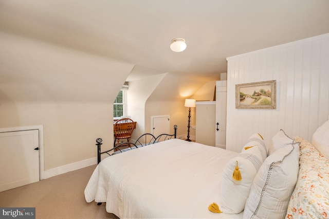 carpeted bedroom with lofted ceiling