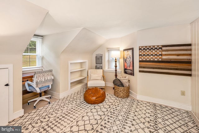 sitting room with built in shelves and vaulted ceiling