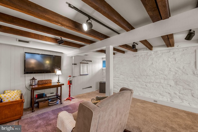 carpeted living room featuring track lighting and beam ceiling