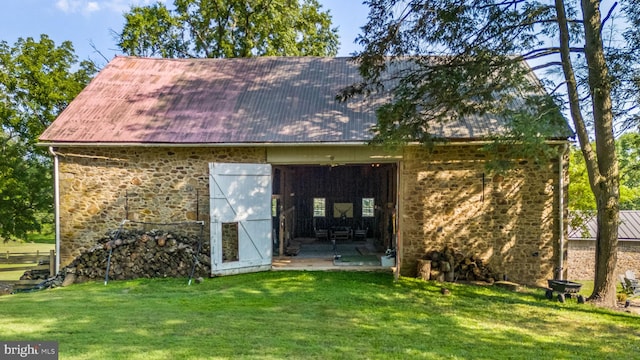 back of house with a lawn and an outbuilding