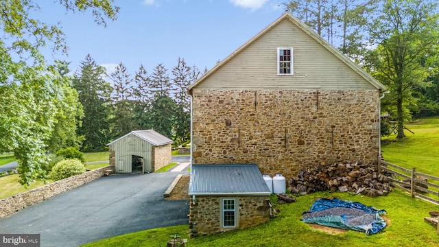 view of home's exterior with a lawn and a storage shed