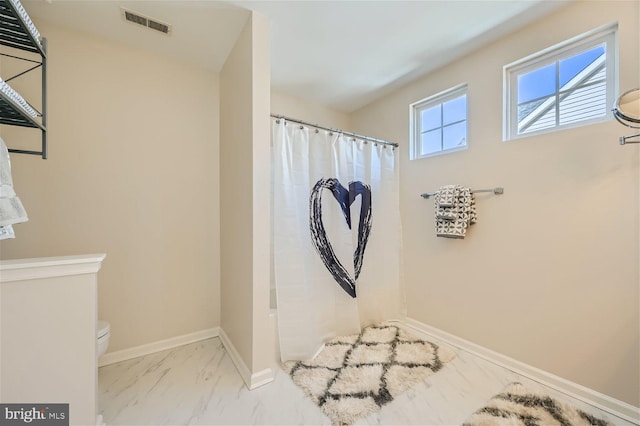 bathroom featuring a shower with curtain and toilet