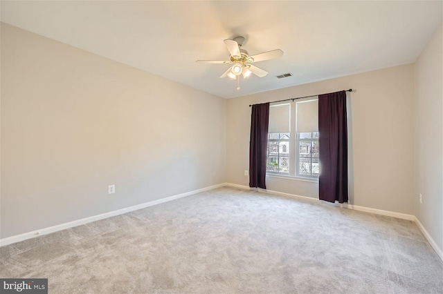 spare room with ceiling fan and light colored carpet