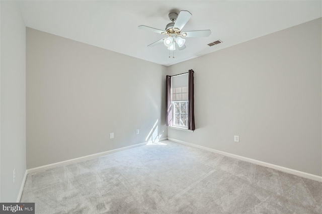 spare room with ceiling fan and light colored carpet