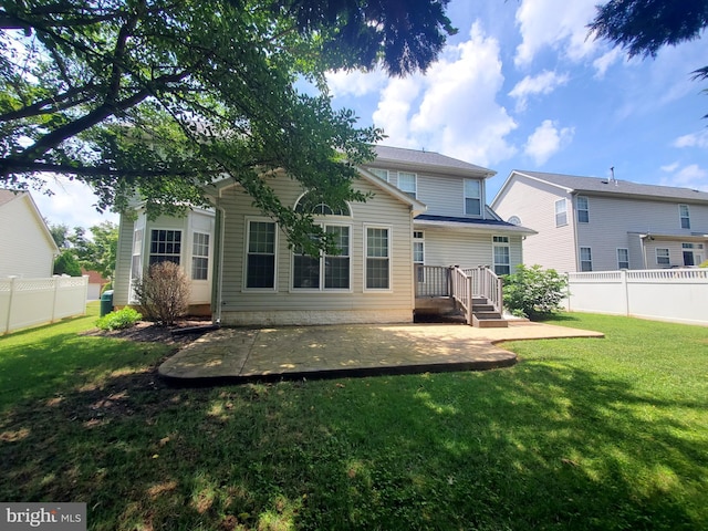 rear view of property featuring a lawn and a patio