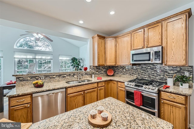 kitchen with decorative backsplash, stainless steel appliances, ceiling fan, sink, and lofted ceiling