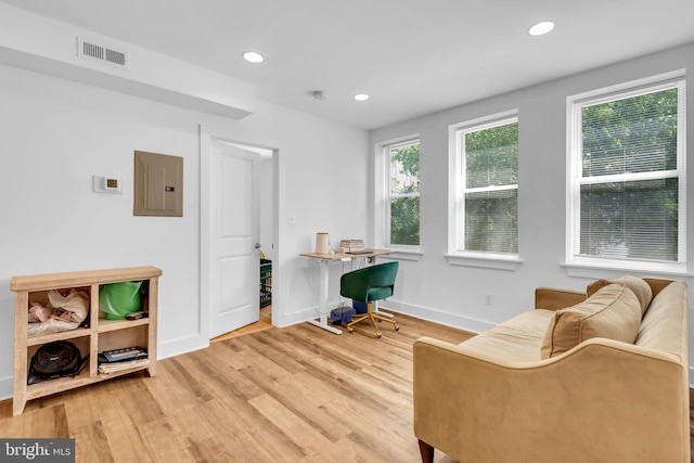 living area featuring electric panel and wood-type flooring