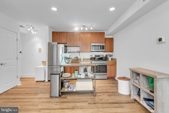 kitchen featuring stainless steel appliances, light hardwood / wood-style flooring, and sink