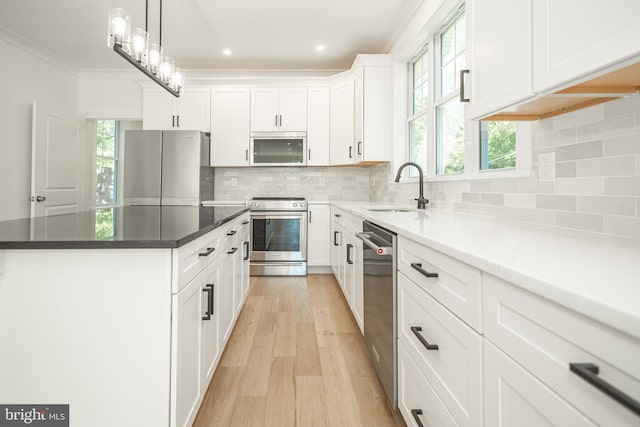 kitchen with tasteful backsplash, light hardwood / wood-style floors, sink, stainless steel appliances, and white cabinets