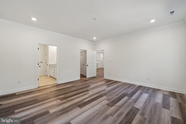 unfurnished bedroom with ensuite bathroom, dark hardwood / wood-style flooring, and ornamental molding