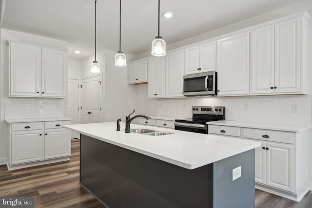 kitchen featuring appliances with stainless steel finishes, white cabinetry, hanging light fixtures, and sink