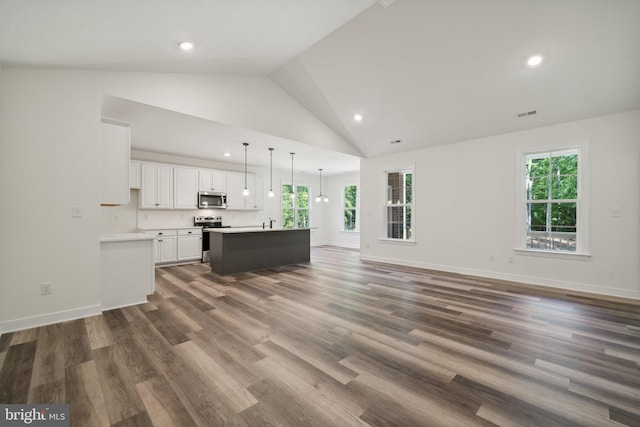 unfurnished living room featuring dark hardwood / wood-style flooring, high vaulted ceiling, and a wealth of natural light