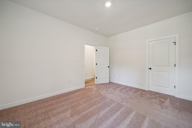 unfurnished room featuring light colored carpet