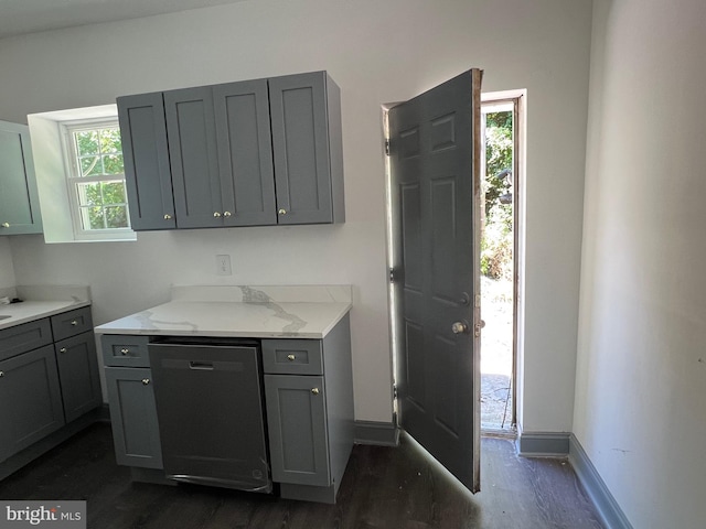 kitchen with dishwashing machine, light stone countertops, dark hardwood / wood-style flooring, and gray cabinetry