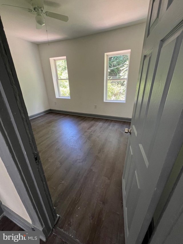 spare room featuring ceiling fan and dark hardwood / wood-style flooring