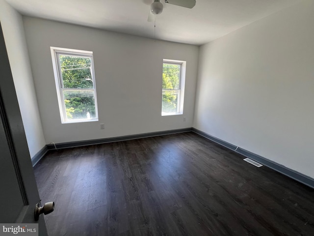 spare room with ceiling fan and dark wood-type flooring