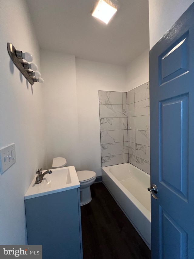 full bathroom featuring toilet, vanity, wood-type flooring, and tiled shower / bath combo