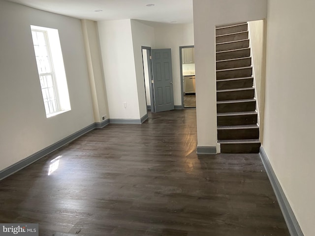 spare room featuring dark wood-type flooring and a healthy amount of sunlight