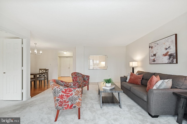 living area featuring light colored carpet and an inviting chandelier