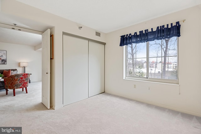 bedroom featuring visible vents, a closet, and light colored carpet