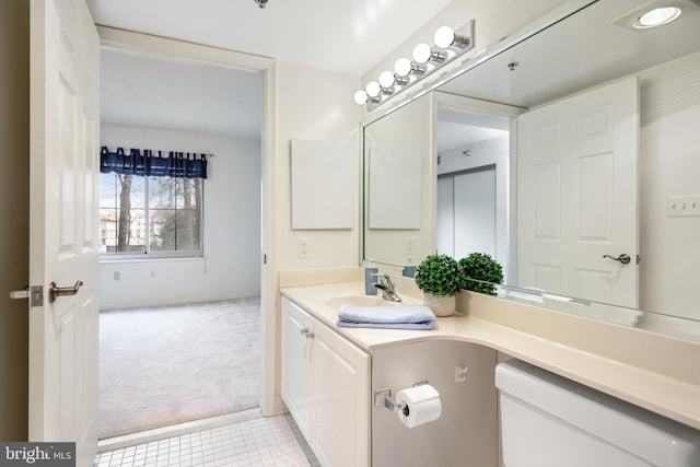 bathroom with toilet, tile patterned flooring, and vanity