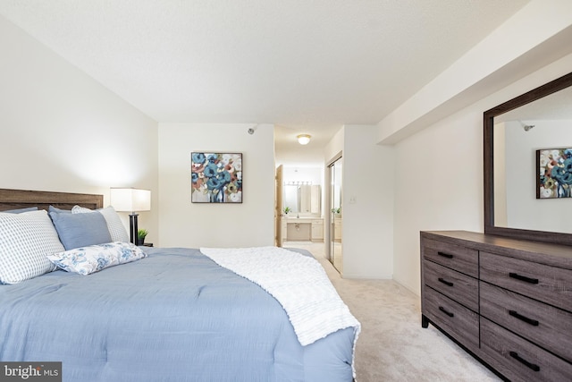 bedroom featuring light carpet and ensuite bath