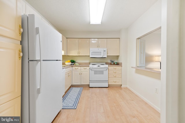 kitchen featuring white appliances, baseboards, light wood-style flooring, light countertops, and a textured ceiling